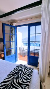 Schlafzimmer mit einem Zebra-Bett und einem Balkon in der Unterkunft Evita Beach Suites Exclusivas in Caleta de Sebo