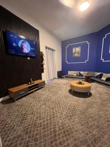 uma grande sala de estar com uma grande televisão numa parede azul em downtown Family Suites no Cairo