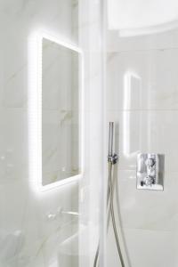 bagno bianco con doccia e specchio di Malila Premium Apartments Cracow Centre Starowiślna 43 a Cracovia
