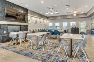 uma sala de jantar com mesas e cadeiras e uma lareira em TownePlace Suites Dallas Arlington North em Arlington