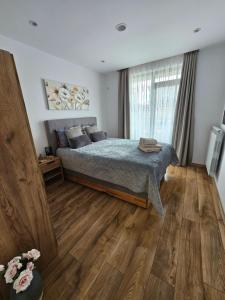 a bedroom with a bed and a wooden floor at Toni's hidden gem in Kazanlŭk