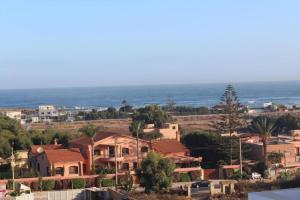 a town with houses and the ocean in the background at Paradis C1 in Mohammedia