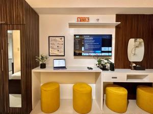 um escritório com uma secretária com um computador e bancos amarelos em Hotel Living,The Persimmon double beds 4pax (904) em Cebu