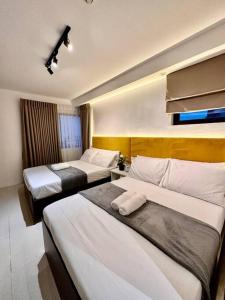 um quarto de hotel com duas camas num quarto em Hotel Living,The Persimmon double beds 4pax (904) em Cebu