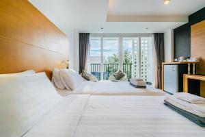 une grande chambre avec un grand lit et un balcon dans l'établissement Vivace Hotel, à Kamala Beach