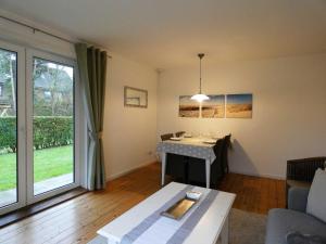 - un salon avec une table et une grande fenêtre dans l'établissement Haus Wiking, à Wyk auf Föhr