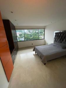 カリにあるAbathar PHのベッドルーム1室(ベッド1台、大きな窓付)