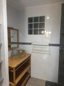 een badkamer met een wastafel en een spiegel bij Pension Cargo in Bras-Panon