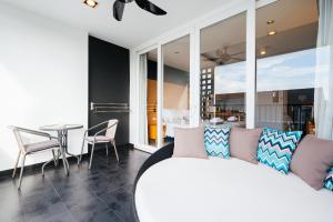 Vivace Hotel في شاطئ كامالا: غرفة معيشة مع أريكة بيضاء وطاولة