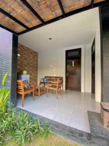 een patio met een tafel en stoelen en een deur bij Meilds Property Kuta in Kuta