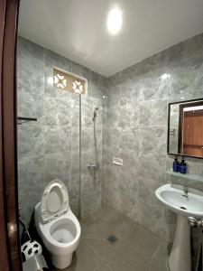 een badkamer met een toilet en een wastafel bij Meilds Property Kuta in Kuta