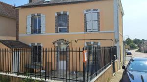 uma casa com uma cerca preta em frente em Serrimmo - appartement Aude em Bléneau