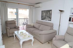 Apartamento en NERJA. Primera línea de playa في نيرخا: غرفة معيشة مع أريكة وطاولة وكراسي