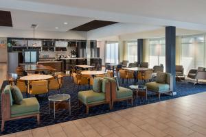 un vestíbulo con mesas y sillas y un bar en Courtyard by Marriott New Haven Wallingford, en Wallingford