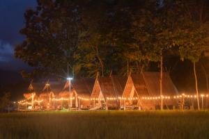 un edificio iluminado por la noche con luces en Paddy Fields Haven - Natures Nest en Pai