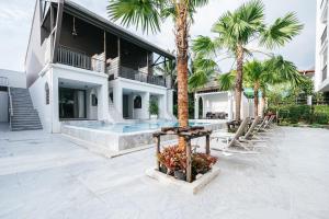 una casa con piscina y palmeras en Vivace Hotel, en Kamala Beach