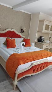 - une chambre dotée d'un grand lit avec des oreillers orange et blancs dans l'établissement Cochet House Sibiu, à Sibiu