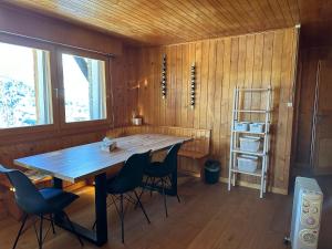 a dining room with a large wooden table and chairs at Chalet Edelweiss à Saint-Martin, Val d'Hérens in Saint-Martin