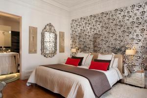 HoHomes - Luxury Palacete في برشلونة: غرفة نوم بسرير كبير ومخدات حمراء