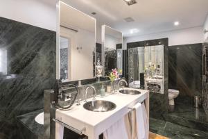uma casa de banho com 2 lavatórios e um espelho grande em HoHomes - Luxury Palacete em Barcelona