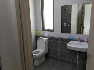 a bathroom with a toilet and a sink at PINTARMAN FAMILY SUITES @ MIRI LUAK BAY in Miri