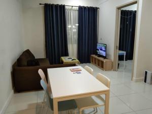 a living room with a table and a couch at PINTARMAN FAMILY SUITES @ MIRI LUAK BAY in Miri