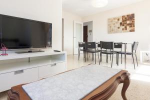 a living room with a tv and a table with chairs at Pubone AT Sabadell in Sabadell