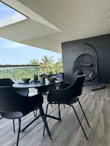 una sala da pranzo con tavolo, sedie e una grande finestra di Far Out Apartments - Kololi Sands a Sere Kunda
