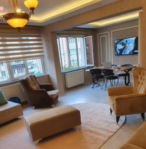 - un salon avec des canapés, une table et des fenêtres dans l'établissement Şehir Merkezinde Otel Konforunda Family House, à Sivas