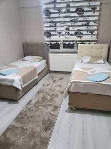 two beds sitting in a room with at Şehir Merkezinde Otel Konforunda Family House in Sivas