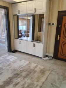 スィヴァスにあるŞehir Merkezinde Otel Konforunda Family Houseのリビングルーム付きの客室で、白い大型キャビネットが備わります。