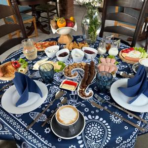 stół z niebiesko-białą tkaniną stołową z jedzeniem w obiekcie Wine Hills w mieście Tbilisi City