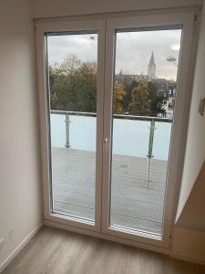 Cette chambre dispose de deux portes coulissantes en verre offrant une vue sur la ville. dans l'établissement City Apartment - 9 Bedrooms - 22 Beds - WiFi - Kitchen, à Paderborn