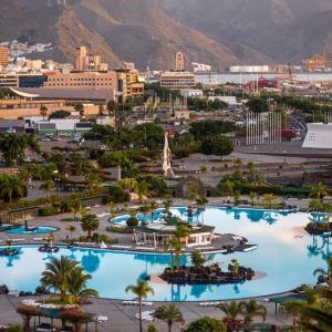 eine Gruppe von Pools mit Palmen in einer Stadt in der Unterkunft Extreme Confort en Santa Cruz Ciudad in Santa Cruz de Tenerife