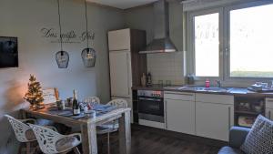 eine Küche mit einem Tisch, einer Spüle und einem Kühlschrank in der Unterkunft Berghaus Weissbriach in Weissbriach