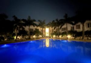 uma piscina em frente a um edifício à noite em A S Hotels em Khajuraho