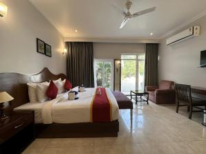 A S Hotels في خاجوراهو: غرفة نوم بسرير كبير وغرفة معيشة