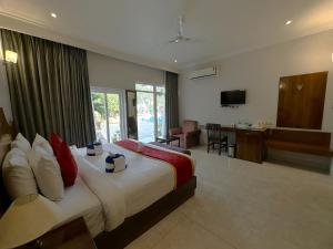 a bedroom with a bed and a desk in a room at A S Hotels in Khajurāho