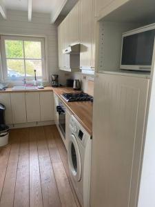 uma cozinha com máquina de lavar e secar roupa em Cottage en bordure bruxelloise em Wezembeek-Oppem