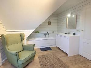 uma casa de banho com um lavatório e uma cadeira num quarto em Cottage en bordure bruxelloise em Wezembeek-Oppem