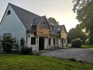 uma casa branca com um telhado de gambrel em Cottage en bordure bruxelloise em Wezembeek-Oppem