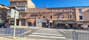 una calle de la ciudad con un paso de peatones frente a un edificio en Hostal El Molino, en Calanda