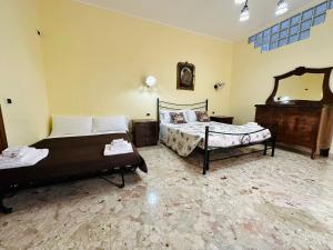 a hotel room with two beds and a mirror at B&B - Piazza Grande in Gela