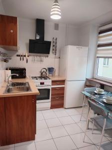 a kitchen with a white refrigerator and a sink at Apartament Baldachówka in Rzeszów