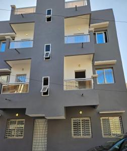 a tall building with windows on the side of it at Appartement entier F3 climatisé agréable, spacieux et confortable à Gadaye in Dakar