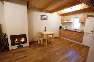 - une cuisine avec une cheminée, une table et une cuisinière dans l'établissement Domek Pietryna, à Chańcza