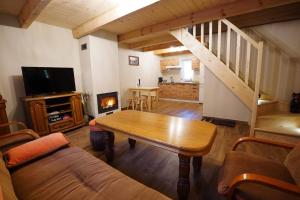 een woonkamer met een houten tafel en een trap bij Domek Pietryna in Chańcza