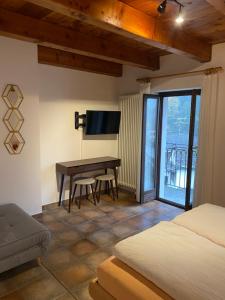 a bedroom with a bed and a desk with a television at Osteria Vittoria in Lavertezzo
