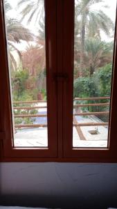 a window looking out at a view of a garden at Riad Nizwa in Nizwa