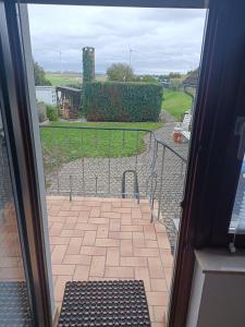 uma porta aberta para um pátio com um banco no exterior em Haus Langert - Einfamilienhaus mit Terrasse und Garten zur alleinigen Nutzung em Baesweiler